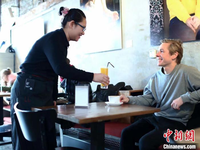 在咖啡馆工作的魏来为客人提供服务。　赵永宏 摄